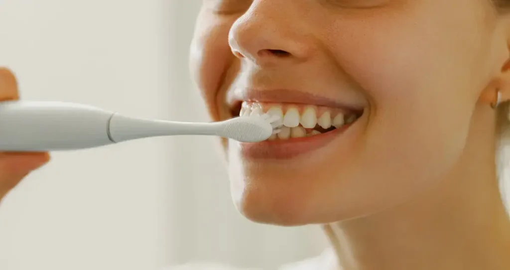 Girl brushing teeth to maintain dental health and proper alignment